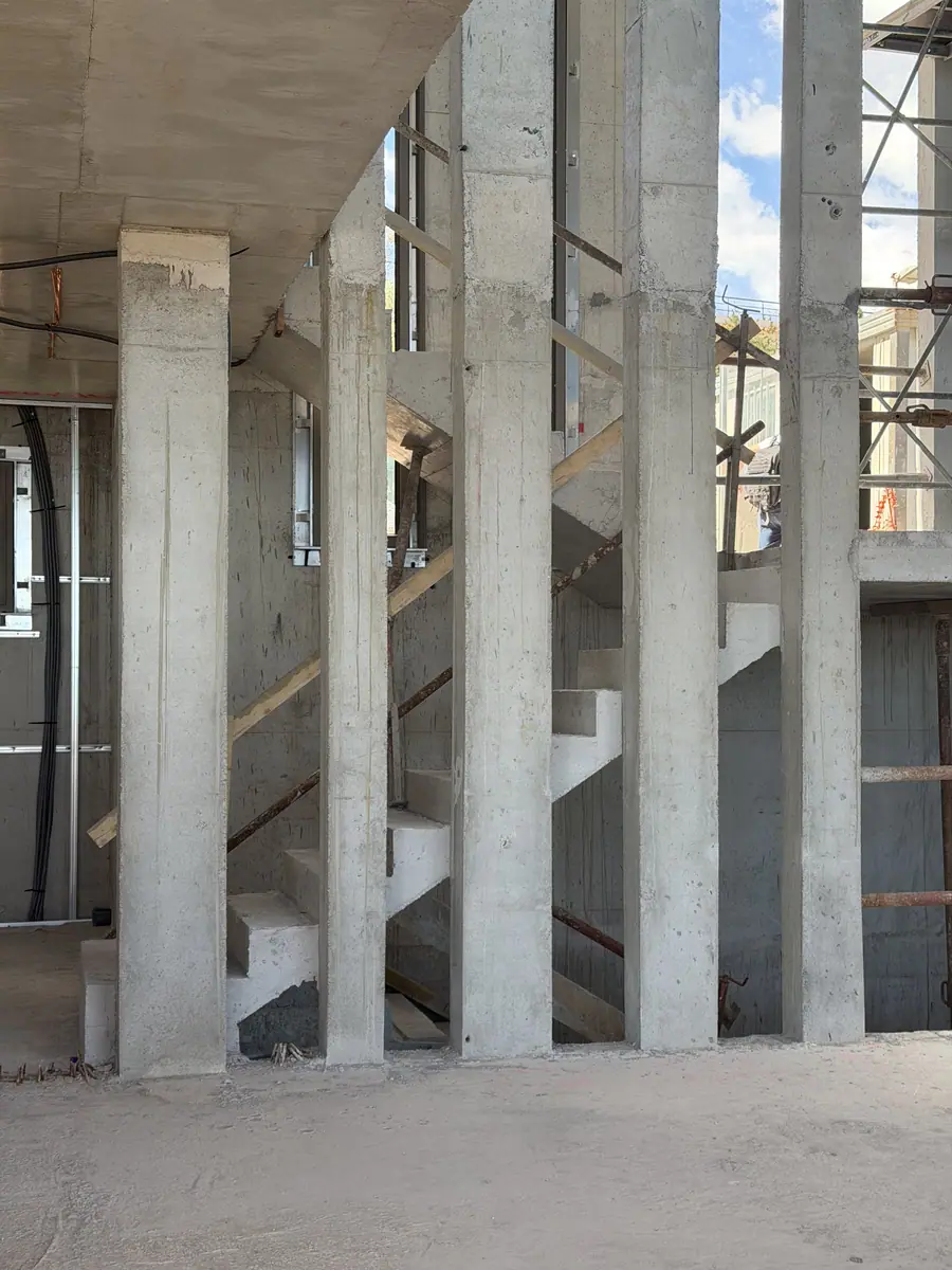 Poteaux et escalier en béton coulés en place, étaiement et échafaudage en cours